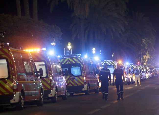 Ambulances line up near the scene of an attack after a truck drove on to the sidewalk and plowed through a crowd of revelers who'd gathered to watch the fireworks in the French resort city of Nice, southern France, Friday, July 15, 2016. A spokesman for France's Interior Ministry says there are likely to be "several dozen dead" after a truck drove into a crowd of revelers celebrating Bastille Day in the French city of Nice. (AP Photo/Claude Paris)
